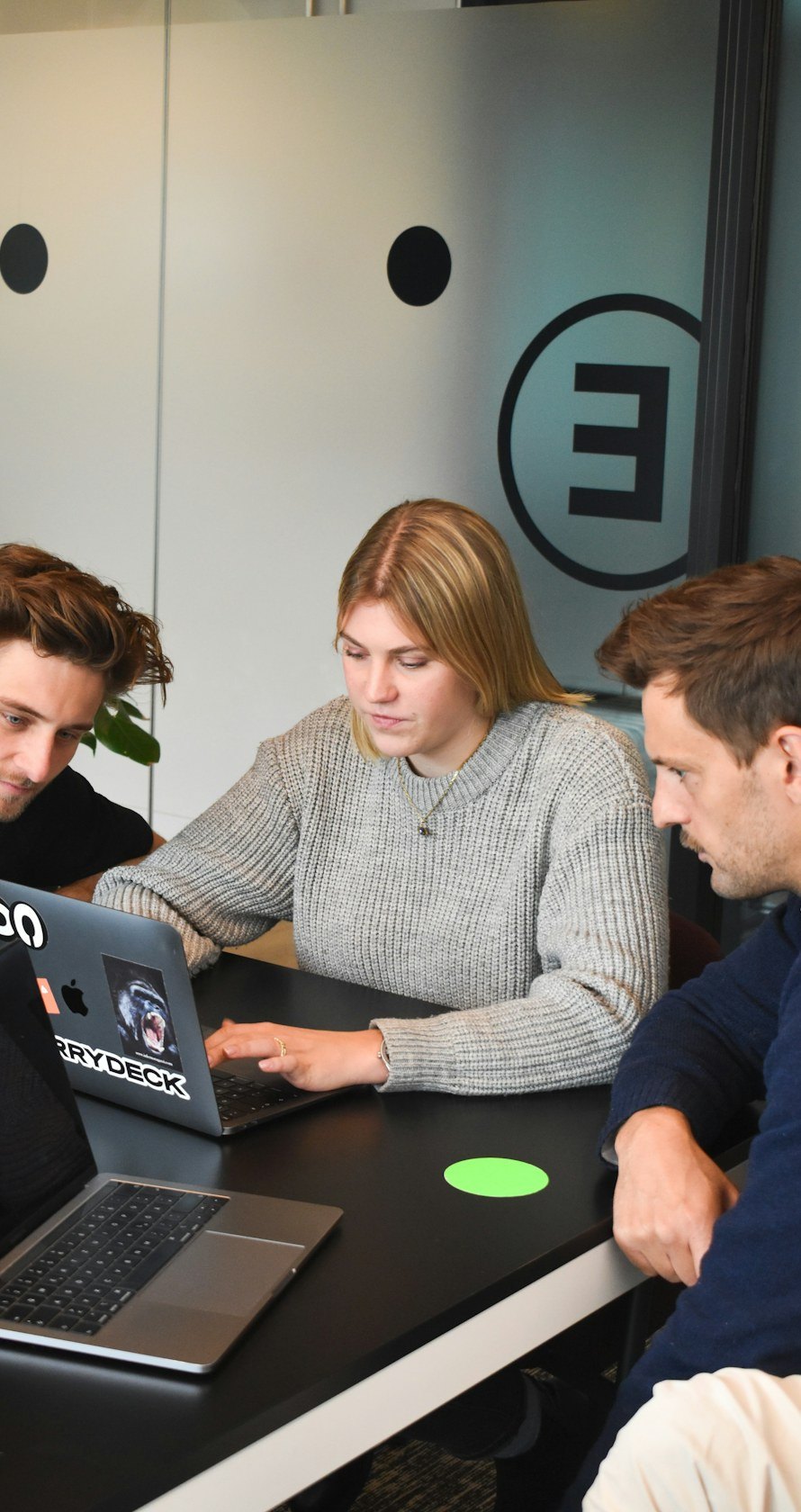 Trois collaborateurs travaillent ensemble sur un ordinateur portable
